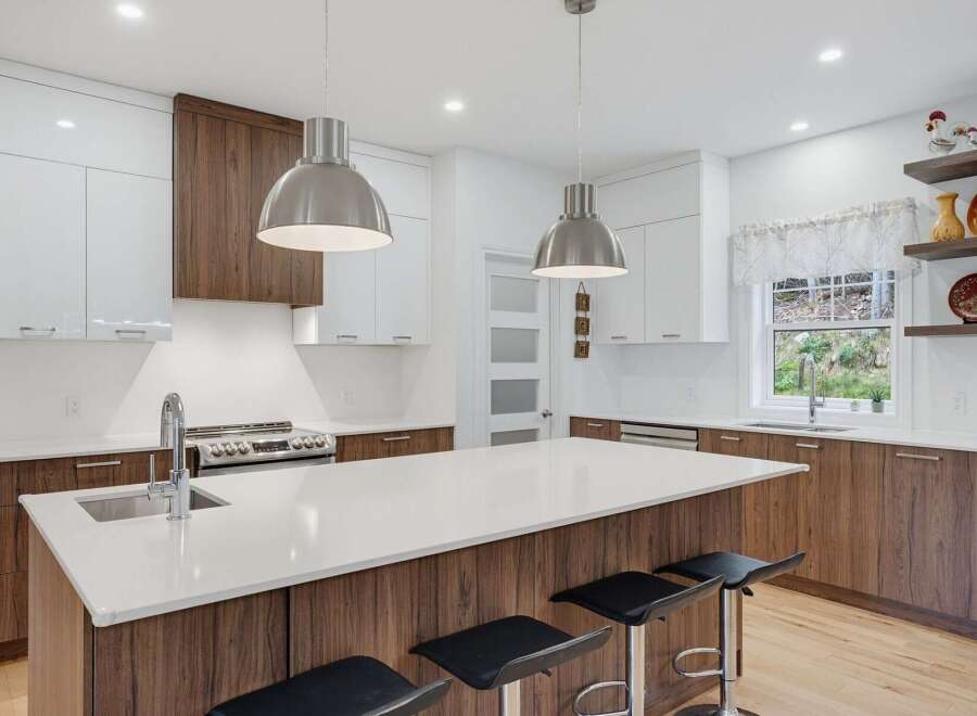 Experience modern living in this stunning kitchen featuring sleek white cabinetry contrasted with rich wood accents.
