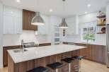 Experience modern living in this stunning kitchen featuring sleek white cabinetry contrasted with rich wood accents.