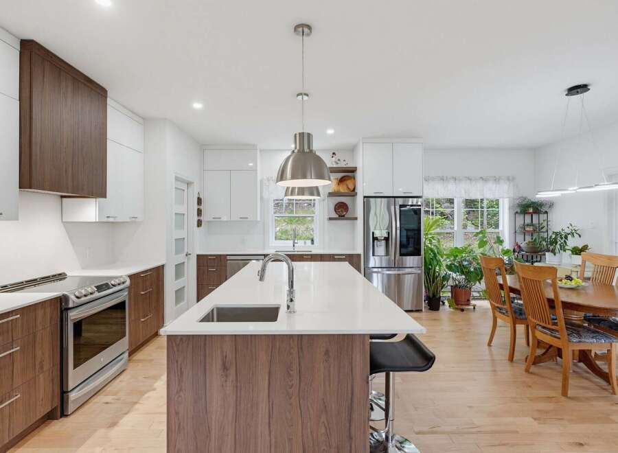Experience modern living in this stunning kitchen featuring sleek white cabinetry contrasted with rich wood accents.
