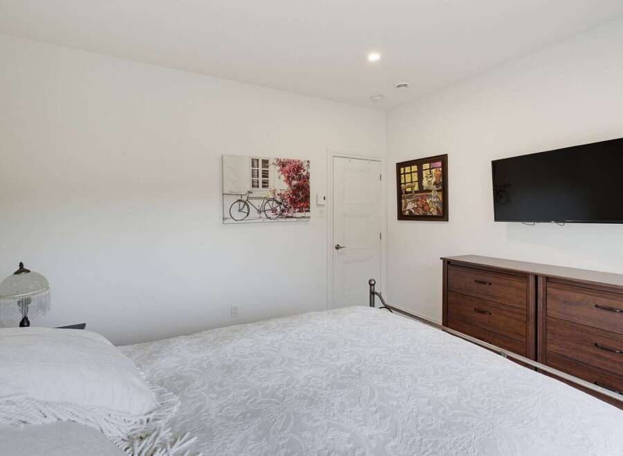 This inviting bedroom features a comfortable bed with a white patterned comforter, perfect for relaxation.