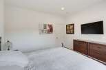 This inviting bedroom features a comfortable bed with a white patterned comforter, perfect for relaxation.