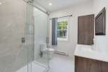 This modern bathroom features a spacious walk-in shower with elegant marble tile and a sleek glass enclosure.