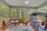 Enjoy the tranquility of nature from this screened-in porch, perfect for outdoor dining or relaxation.