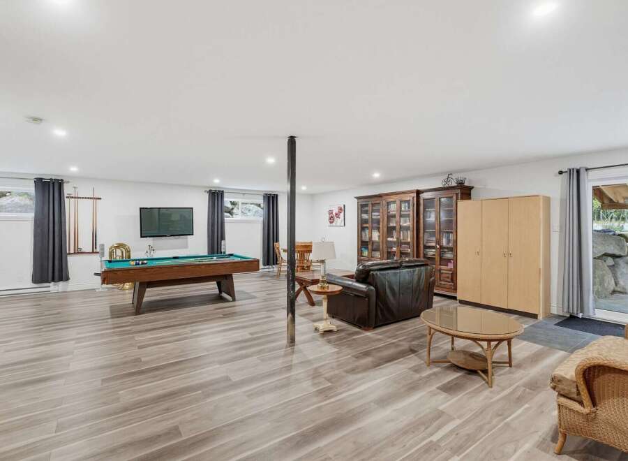 This spacious basement recreation room offers endless entertainment possibilities with a full-sized pool table and a cozy seating area.