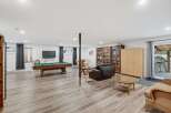 This spacious basement recreation room offers endless entertainment possibilities with a full-sized pool table and a cozy seating area.