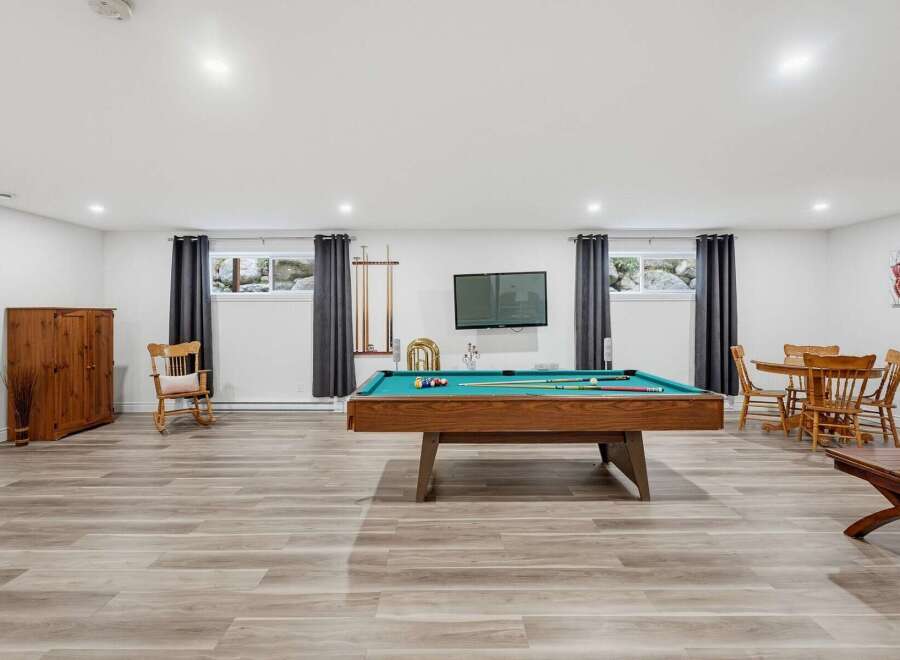 Enjoy endless entertainment in this versatile basement space, featuring a professional-grade pool table perfect for friendly games.