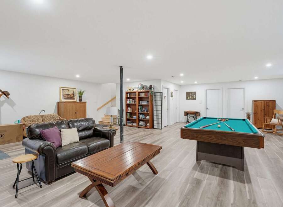This spacious basement recreation room offers endless entertainment possibilities, featuring a full-size pool table ready for your next game night.