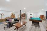 This spacious basement recreation room offers endless entertainment possibilities, featuring a full-size pool table ready for your next game night.