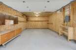 This spacious garage offers ample storage with custom wood cabinetry and multiple shelving units.