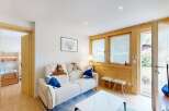 This charming living room features a comfortable white sofa adorned with faux fur throws and blue accent pillows, creating a cozy atmosphere.