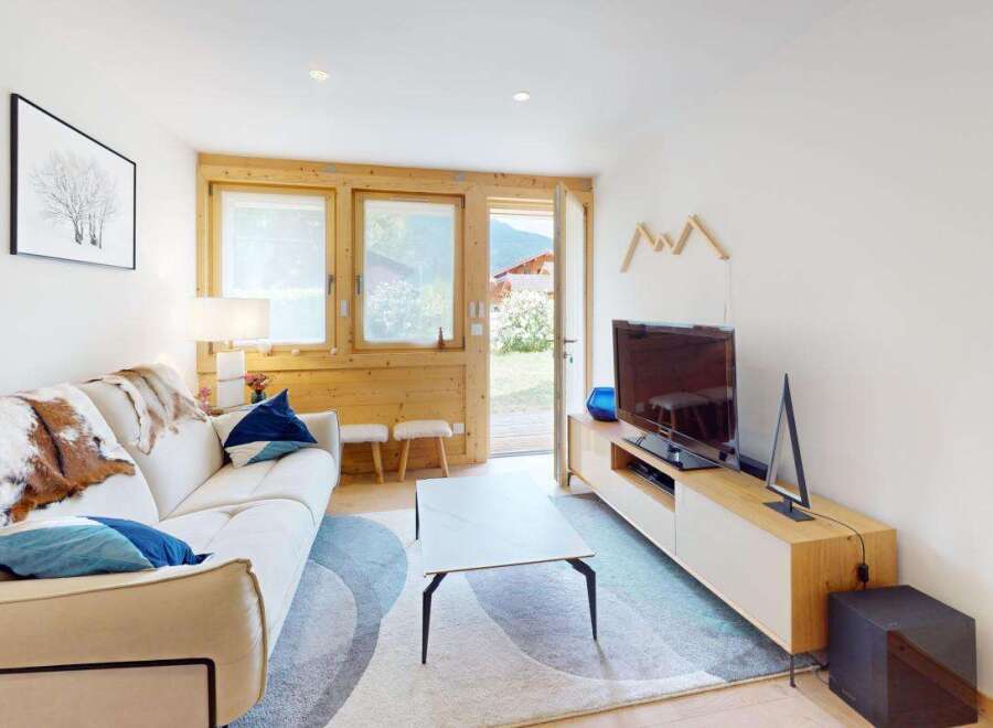 Experience cozy living in this charming mountain retreat, featuring a comfortable sofa adorned with rustic cowhide throws and plush blue pillows.