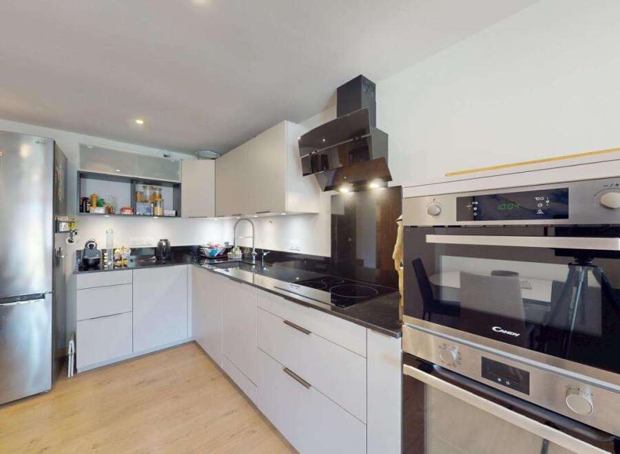This modern kitchen boasts a sleek, integrated design with ample storage and high-end appliances.