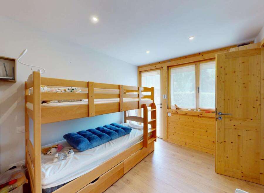 Discover this charming room featuring a sturdy wooden bunk bed, perfect for families or guests.