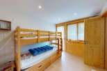 Discover this charming room featuring a sturdy wooden bunk bed, perfect for families or guests.