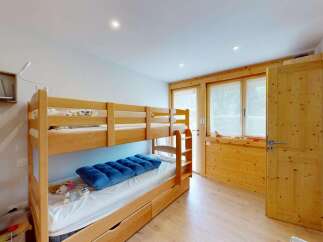 Discover this charming room featuring a sturdy wooden bunk bed, perfect for families or guests.