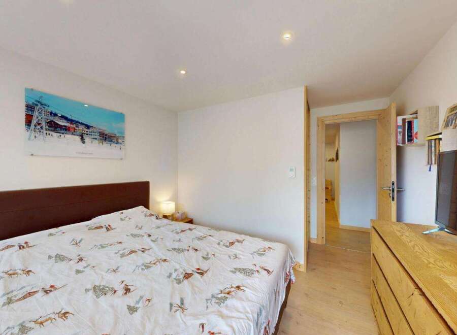 This cozy bedroom features a comfortable bed with a unique ski-themed duvet cover, perfect for a winter getaway.