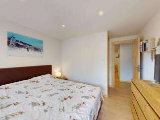 This cozy bedroom features a comfortable bed with a unique ski-themed duvet cover, perfect for a winter getaway.
