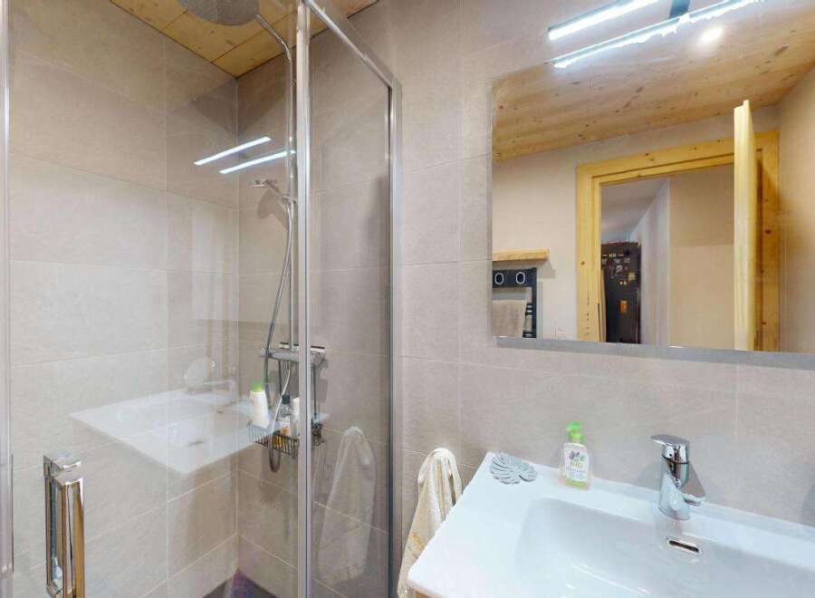 Experience modern comfort in this beautifully appointed bathroom, featuring a sleek glass-enclosed shower and a spacious vanity with a contemporary faucet.