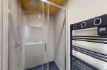 Experience modern comfort in this stylish bathroom featuring a sleek glass-enclosed shower with a rainfall showerhead.