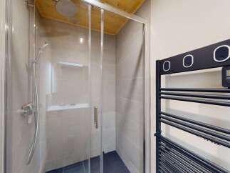 Experience modern comfort in this stylish bathroom featuring a sleek glass-enclosed shower with a rainfall showerhead.
