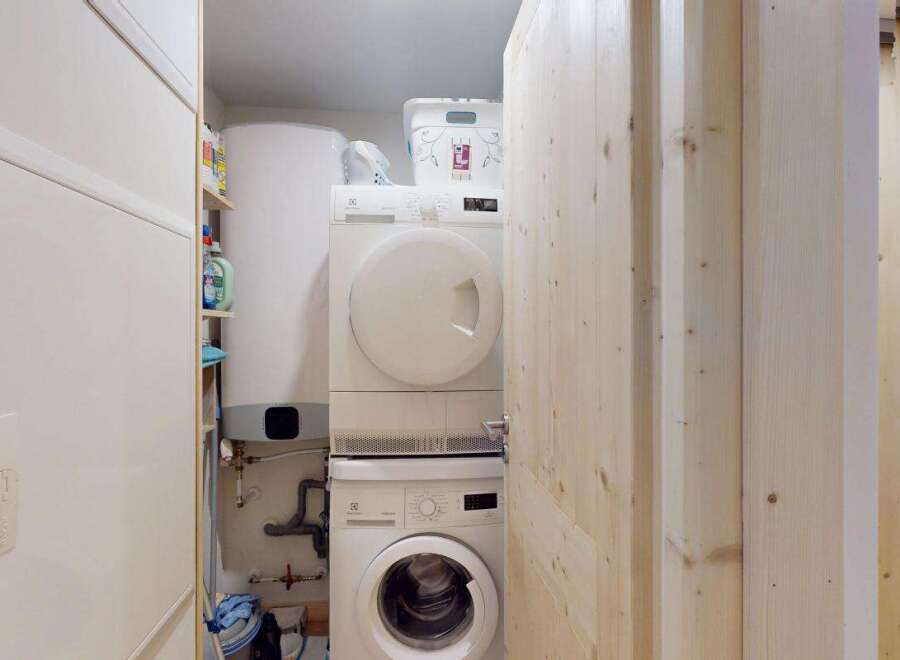 Discover a functional laundry area featuring a stacked washer and dryer, perfect for maximizing space.