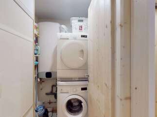 Discover a functional laundry area featuring a stacked washer and dryer, perfect for maximizing space.
