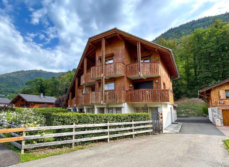 Experience alpine living in this charming wooden chalet, nestled against a backdrop of lush green mountains.