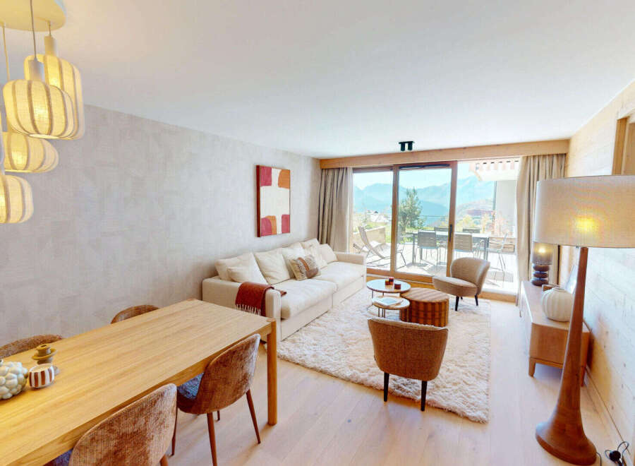 Experience breathtaking mountain views from this stunning living space, featuring a plush sectional sofa and a cozy dining area perfect for family meals.