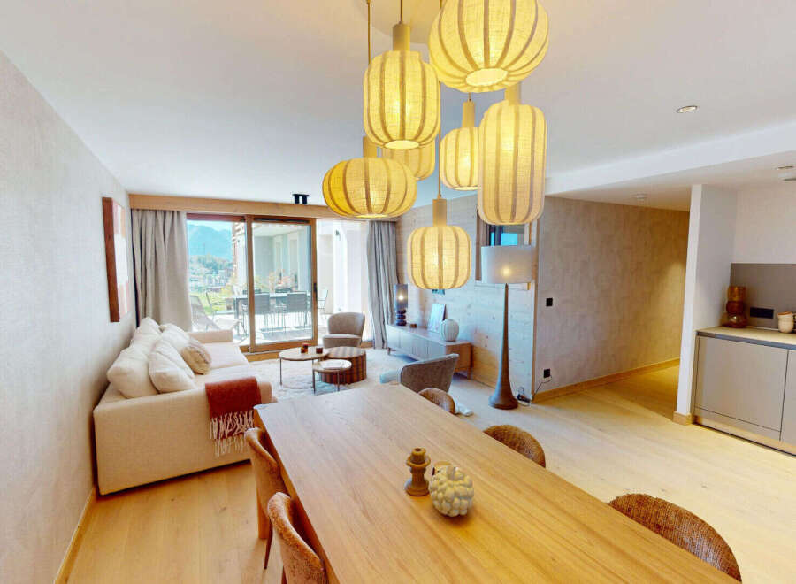 Experience modern living in this beautifully appointed open-plan space, featuring a comfortable living area with a plush sofa and a stylish dining area perfect for entertaining.