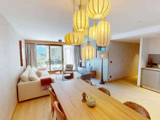 Experience modern living in this beautifully appointed open-plan space, featuring a comfortable living area with a plush sofa and a stylish dining area perfect for entertaining.