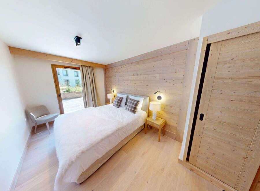 Experience cozy mountain living in this charming bedroom featuring a plush white duvet and a rustic wooden accent wall.