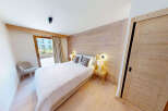 Experience cozy mountain living in this charming bedroom featuring a plush white duvet and a rustic wooden accent wall.