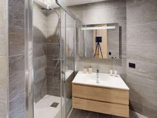 Experience modern luxury in this stunning bathroom featuring a spacious glass-enclosed shower and a sleek vanity with ample storage.