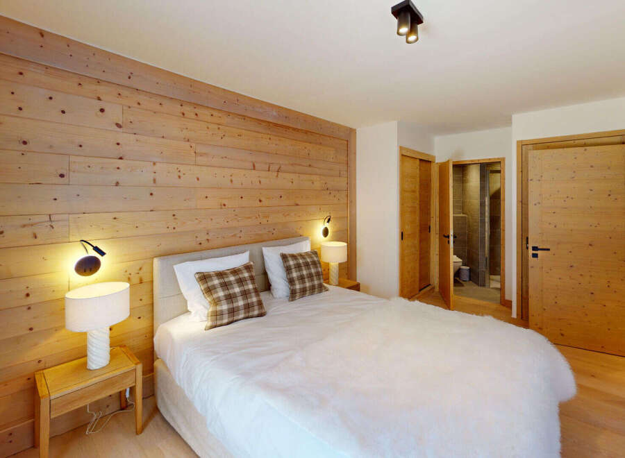 Experience rustic charm in this cozy bedroom featuring a stunning wooden accent wall that adds warmth and character.