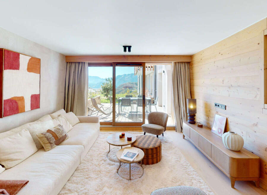 Experience modern alpine living in this stunning living room, featuring a plush sectional sofa and a unique stacked coffee table.