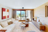 Experience modern alpine living in this stunning living room, featuring a plush sectional sofa and a unique stacked coffee table.