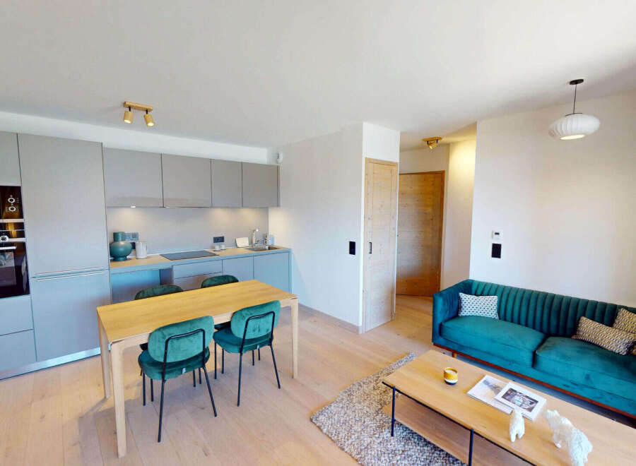 Experience modern living in this open-concept apartment featuring a sleek, integrated kitchen with high-end appliances and ample cabinet space.