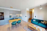 Experience modern living in this open-concept apartment featuring a sleek, integrated kitchen with high-end appliances and ample cabinet space.