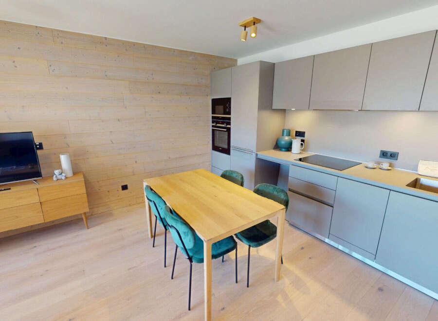 Experience modern living in this beautifully appointed apartment, featuring a sleek, integrated kitchen with ample cabinet space and a stylish dining area perfect for intimate meals.