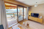 Experience mountain living in this charming apartment featuring a spacious living area with a modern entertainment center and a cozy balcony perfect for enjoying the scenic views.