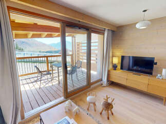 Experience mountain living in this charming apartment featuring a spacious living area with a modern entertainment center and a cozy balcony perfect for enjoying the scenic views.