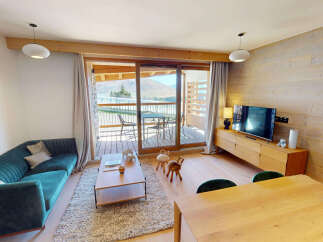 Experience modern mountain living in this beautifully appointed living space, featuring a plush teal sofa and a rustic wooden entertainment center.
