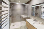 Experience modern comfort in this beautifully appointed bathroom, featuring a spacious walk-in shower with a built-in seat and sleek glass enclosure.