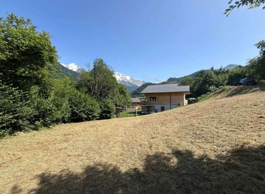 Experience the charm of mountain living in this picturesque property featuring a modern wooden chalet nestled amidst lush greenery.