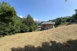 Experience the charm of mountain living in this picturesque property featuring a modern wooden chalet nestled amidst lush greenery.