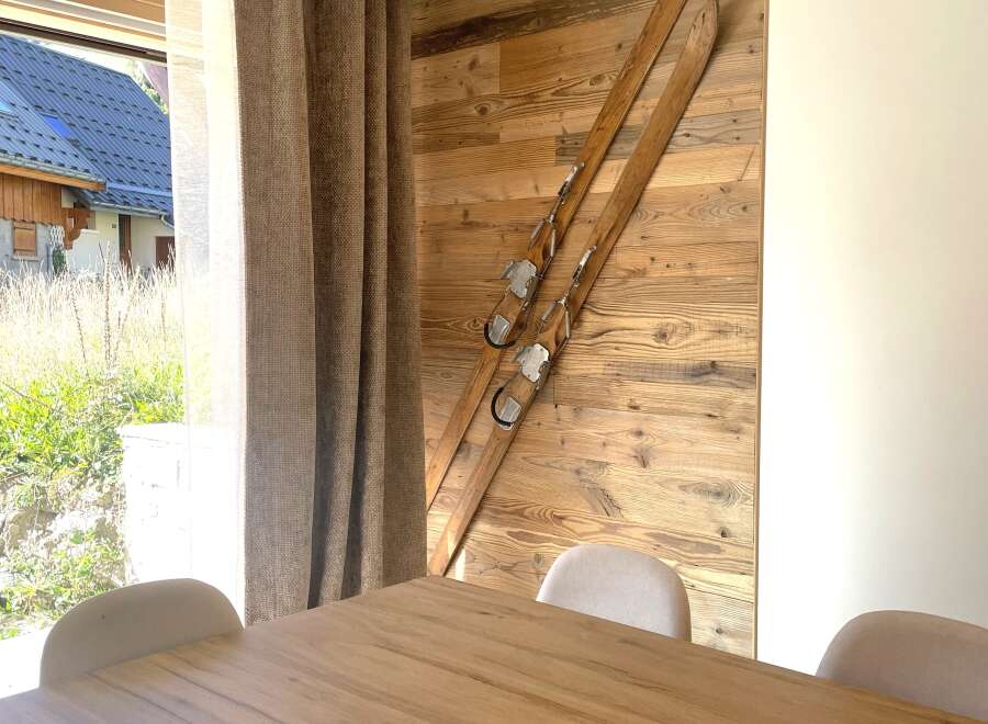 Experience rustic charm with this beautifully decorated interior featuring a wooden accent wall adorned with vintage skis.