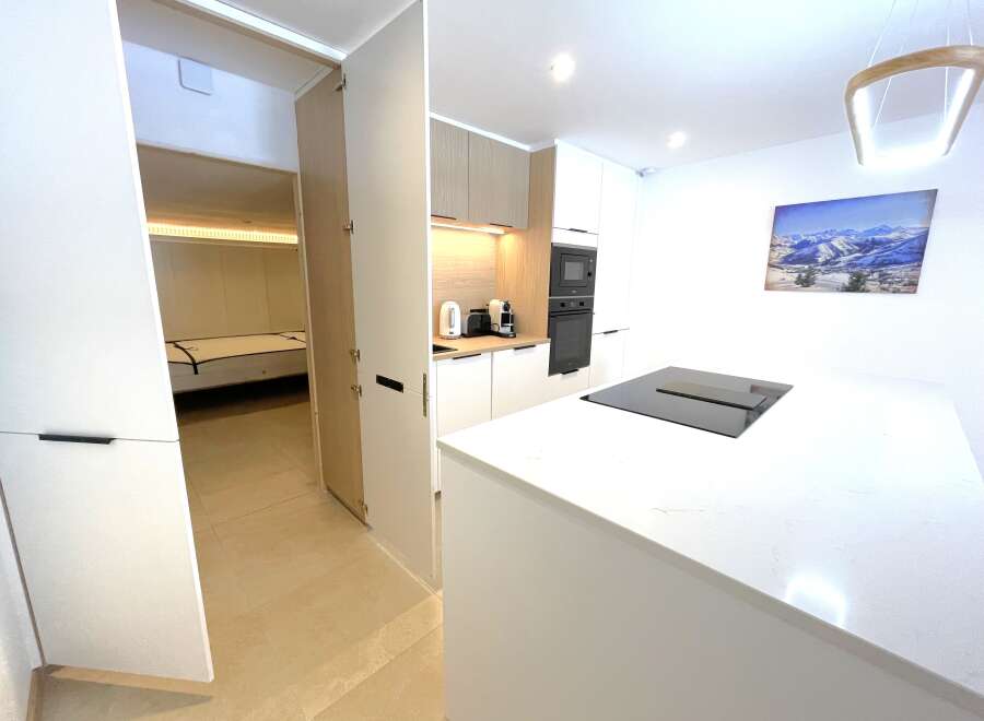 Discover modern living in this beautifully appointed kitchen featuring sleek white countertops and integrated appliances.