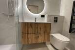 Experience modern luxury in this stunning bathroom featuring a sleek vanity with ample storage and a floating design.
