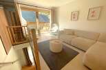 Experience modern living in this beautifully appointed apartment, featuring a spacious living area with a plush sectional sofa and a stylish round coffee table.