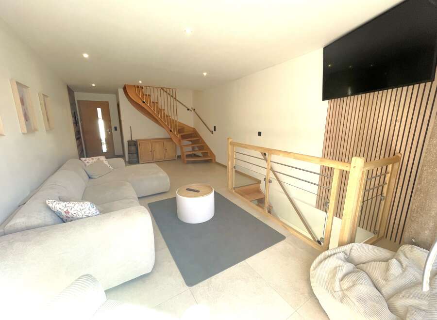 Step into this modern living space featuring a comfortable sectional sofa and a stylish round coffee table.